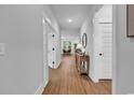 Hallway with wooden floors, white trim, and views to the living room and dining area beyond at 1216 Newell Dr, Myrtle Beach, SC 29588