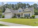 Inviting home with a two-car garage, manicured lawn, and covered front porch at 1448 Tiger Grand Dr., Conway, SC 29526