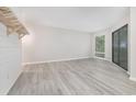 Living room with light-grey wood-look flooring and sliding glass door offers an open concept at 1500 Cenith Dr. # B-403, North Myrtle Beach, SC 29582