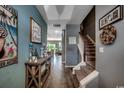 Hallway with beautiful wood-look floors leads to staircase and open concept kitchen and living areas at 153 Goldenrod Circle # 7D, Little River, SC 29566