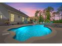 Beautiful backyard pool with a stone waterfall feature, covered patio, and comfortable lounge furniture at 1715 Lake Egret Dr., North Myrtle Beach, SC 29582