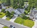 Aerial view of a charming two-story home with a manicured lawn in a tree-lined neighborhood at 185 Rocko Dr., Myrtle Beach, SC 29579