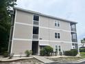 View of condo exterior featuring a multi-story building, green landscaping, and a labeled entrance at 2498 Coastline Ct. # 301, Murrells Inlet, SC 29576
