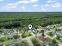 Aerial view of a single-Gathering home surrounded by trees and neighborhood with a pond in the background at 2738 Canvasback Trail, Myrtle Beach, SC 29588