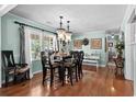 Elegant dining room with hardwood floors, stylish chandelier, and ample natural light from large windows at 280 Morgan Ave., Little River, SC 29566