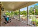 Inviting covered front porch with brick flooring, white railing, and comfortable rocking chairs at 280 Morgan Ave., Little River, SC 29566