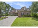 Charming brick home with manicured lawn, paver driveway, and mature trees at 280 Oatland Lake Rd., Pawleys Island, SC 29585