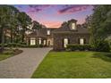 Brick home with paver driveway, lush lawn, and a colorful sunset backdrop at 280 Oatland Lake Rd., Pawleys Island, SC 29585