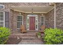 Inviting front porch with brick steps, red door, and seating area at 280 Oatland Lake Rd., Pawleys Island, SC 29585