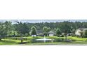 Scenic view of neighborhood pond with fountain, lush landscaping, and well-maintained homes at 309 Outboard Dr., Murrells Inlet, SC 29576
