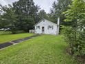 A cozy one-story home with green shutters and lush green lawn and mature trees at 331 Dixon St., Mullins, SC 29574