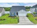Charming single-story home features a two-car garage, manicured lawn, and stylish curb appeal at 346 High Falls Dr., Conway, SC 29526