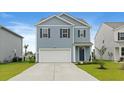 Charming two-story home with blue siding, a two-car garage, and well-manicured landscaping at 3657 Bells Lake Circle, Longs, SC 29568