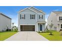 Charming two-story home with blue siding, a two-car garage, and well-manicured landscaping at 3657 Bells Lake Circle, Longs, SC 29568