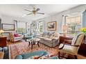 Bright living room featuring hardwood floors, many windows, comfortable seating, ceiling fan, and a colorful area rug at 401 Harmon Park Blvd., Marion, SC 29571