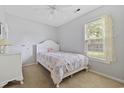 Cozy bedroom features a bright window, plush carpet, and a stylish bed frame with a decorative comforter at 402 Bristlecone St., Longs, SC 29568