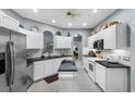 Bright kitchen features white cabinets, stainless appliances, granite countertops, and a tiled floor at 4228 Friendfield Trace, Little River, SC 29566