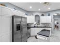Bright kitchen features white cabinets, stainless appliances, granite countertops, and a tiled floor at 4228 Friendfield Trace, Little River, SC 29566