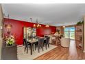 Cozy living room with red accent wall, dining area, and sliding doors to a balcony at 4366 Rivergate Ln. # 306, Little River, SC 29566