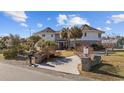 Unique round home with a brick and white exterior, palm trees, and a welcoming driveway at 4552 River Rd., Little River, SC 29566