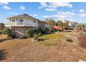Large round two-story home with balcony and brick facade, set in a spacious yard at 4552 River Rd., Little River, SC 29566