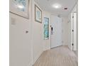 Hallway with unique stained glass window accents and a wood grain tile floor leading to a white door at 4800 S Ocean Blvd. # 920, North Myrtle Beach, SC 29582
