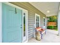 Inviting front porch with a bench, swing and a blue front door creating a cozy outdoor space at 4867 Wolf Trail, Conway, SC 29527