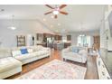 Open-concept living room featuring hardwood floors, neutral decor, and seamless flow to the kitchen and dining area at 4867 Wolf Trail, Conway, SC 29527