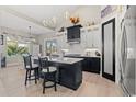 Open kitchen with modern pendant lighting, two-tone cabinets, island with stools, and stainless appliances at 558 Oxbow Dr., Myrtle Beach, SC 29579
