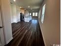 Open-concept living space boasts hardwood flooring, bright windows, and seamless flow into the kitchen and dining areas at 594 Castillo Dr., Loris, SC 29569