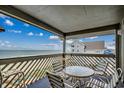 Relaxing covered balcony with table and chairs, perfect for enjoying the beach views and ocean breeze at 618 N Waccamaw Dr. # B7, Garden City Beach, SC 29576