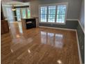 Spacious living room featuring hardwood floors, a fireplace, and a large window at 6542 Wellington Dr., Murrells Inlet, SC 29576
