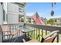 Cozy outdoor balcony featuring seating with views of the community and an American Flag at 7700 Porcher Dr. # 3205, Myrtle Beach, SC 29572