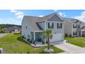 Well-maintained two-story home with gray siding, a two-car garage, and attractive landscaping including a palm tree at 798 Woodland Farms Circle, Aynor, SC 29511