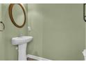 Stylish half-bathroom featuring a pedestal sink, framed mirror, and green walls at 945 Rosencrans Ln. # B, Myrtle Beach, SC 29577