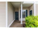 Covered entryway featuring a dark green door and window with dark green shutters at 964 Great Egret Circle Sw # B, Sunset Beach, NC 28468