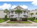 Inviting condo with a lush landscape and white staircases leading to the covered porches at 964 Great Egret Circle Sw # B, Sunset Beach, NC 28468