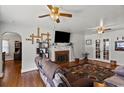 Cozy living room featuring a brick fireplace, hardwood floors, and two ceiling fans for ultimate comfort and style at 1008 N Withlacoochee Ave., Marion, SC 29571