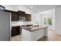 Modern kitchen boasts stainless steel appliances, dark cabinets, a center island, and a bright window at 124 Shady Arbor Loop, Longs, SC 29568