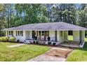 Charming single-story white brick home featuring a well-manicured lawn, driveway and cozy front porch at 265 Powell Loop, Andrews, SC 29510