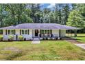 Charming single-story white brick home featuring a well-manicured lawn and cozy front porch at 265 Powell Loop, Andrews, SC 29510