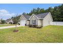 Well-maintained home with light siding, a manicured lawn, and mature trees for added privacy at 276 Avery Dr., Myrtle Beach, SC 29588