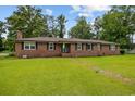 Traditional brick ranch-style home featuring black shutters and a green lawn at 300 Crescent Dr., Conway, SC 29526