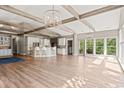 Bright living room showcasing wood beams, hardwood floors, and large windows allowing ample natural light at 3597 Sunfish St., Murrells Inlet, SC 29576