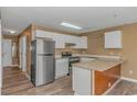 Bright kitchen featuring white cabinets, stainless steel appliances, granite countertops, and wood look flooring at 3700 Golf Colony Lane # 25-D, Little River, SC 29566