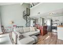 Inviting living room with a spiral staircase, comfortable sofa, and a kitchen view at 3700 Golf Colony Lane # 2-J, Little River, SC 29566