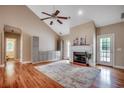 Bright living room boasts a fireplace, hardwood floors, a ceiling fan, and access to the bathroom at 391 William Nobles Rd., Aynor, SC 29511
