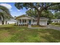 Charming single-story home featuring a well-manicured lawn and an inviting front porch with blue shutters at 412 Middleton Dr., Pawleys Island, SC 29585