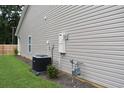 Home exterior featuring vinyl siding, an HVAC unit, gas meter, and a window, surrounded by green grass at 419 White Willow Way, Longs, SC 29568