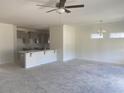 Open concept living room featuring a ceiling fan, kitchen area, and bright natural light at 419 White Willow Way, Longs, SC 29568